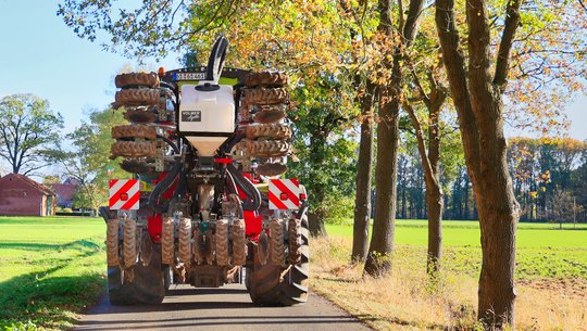 Xerion mit eingeklappten Strip Till Gerät und Kieserit Schleuse von hinten